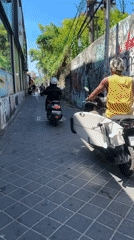 Tourist documents street scenes while shopping in Kuta, Bali