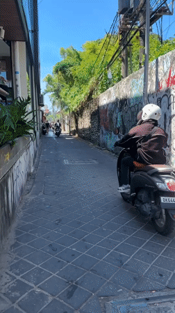 Tourist documents street scenes while shopping in Kuta, Bali