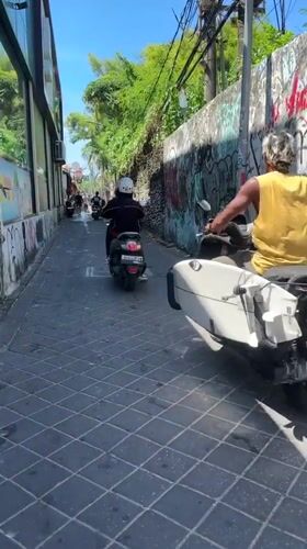 Tourist documents street scenes while shopping in Kuta, Bali