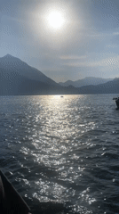 Ferry carries red Mustang across Lake Como at Varenna