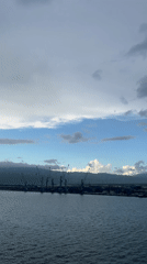 Harbor with shipping containers observed under cloudy skies