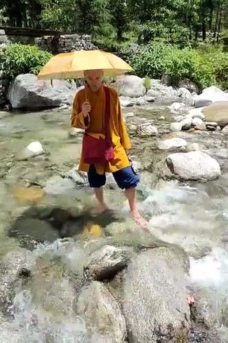 Morning scenes of monk crossing streams and children playing in rural India