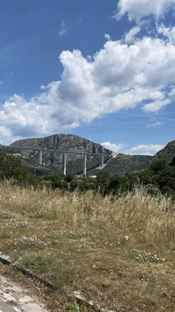 White bridge spans green valley in Montenegro mountains
