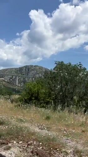 White bridge spans green valley in Montenegro mountains