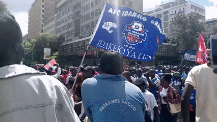 Football fans march through downtown Nairobi with AFC flags