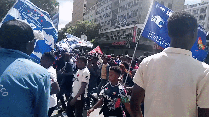 Football fans march through downtown Nairobi with AFC flags