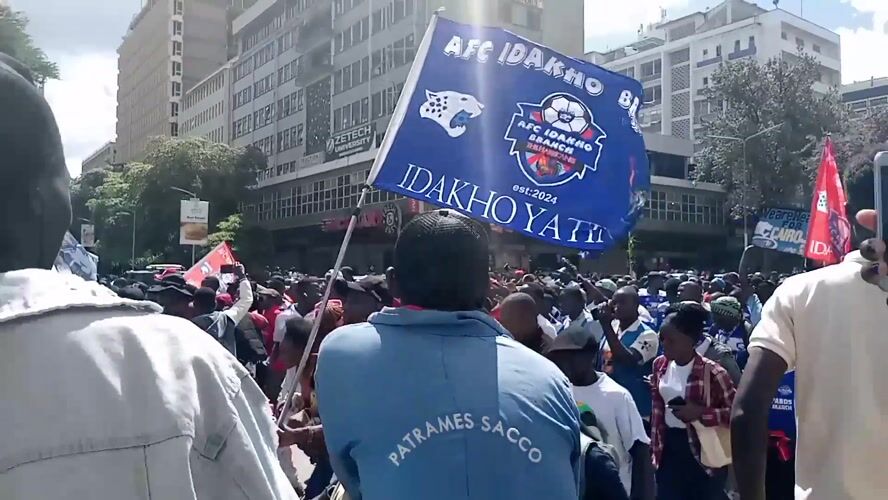 Football fans march through downtown Nairobi with AFC flags