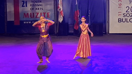 Traditional Indian dance pairs perform under purple stage lights