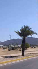Vehicle drives through Juan Griego on clear afternoon