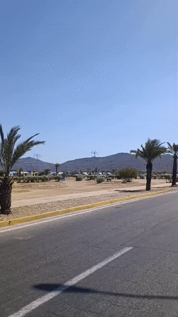 Vehicle drives through Juan Griego on clear afternoon