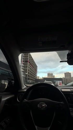 Driver photographs modern building from car in Kyiv