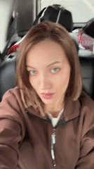 Woman records selfie video from car passenger seat in Klin