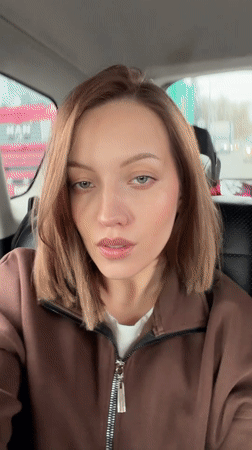 Woman records selfie video from car passenger seat in Klin