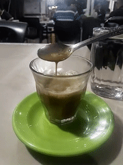 Coffee break captured at Lhokseumawe cafe with phone scrolling