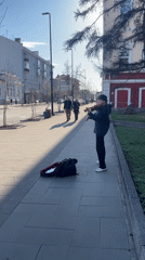Young street musician performs violin on Krasnoyarsk sidewalk