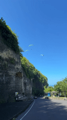 Paragliders soar over Indonesian coastal cliffs in morning flight