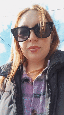 Woman pushes stroller through rural Russian town morning walk