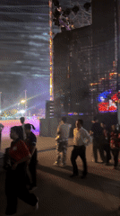 Nighttime activity captured near stage and illuminated bridge in Vietnam
