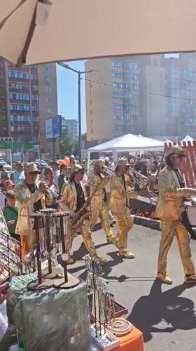 Gold-uniformed brass band parades through Dubna streets