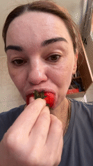 Woman enjoys fresh strawberries in Saint Petersburg apartment