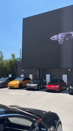 Teslas gather at West Hollywood LED display showing mixed content