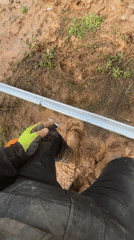Worker takes cigarette break in muddy Bulgarian field