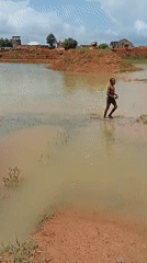 Kids play in floodwaters surrounding buildings in rural Nigeria