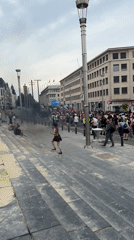 Smoke and crowds in central Brussels amid city landmarks