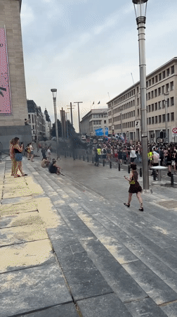 Smoke and crowds in central Brussels amid city landmarks