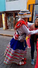 Traditional-dressed person playfully interacts with woman on Arequipa street