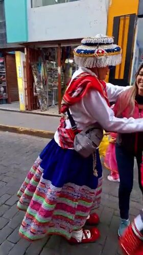 Traditional-dressed person playfully interacts with woman on Arequipa street