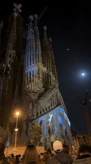 Crowds gather to photograph illuminated Sagrada Familia in Barcelona