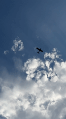 Small plane silhouetted against a sunlit sky over Wrocław