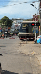 Train crosses intersection, Buddha statue visible in Nha Trang