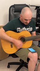 Man plays acoustic guitar in office chair in Yekaterinburg