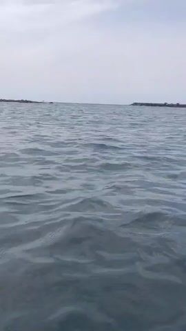 The video shows an ocean view. The first few seconds show the ocean surface and sky, with faint land visible in the distance. The last few seconds show the underwater view of the ocean with sunlight shining through the water.