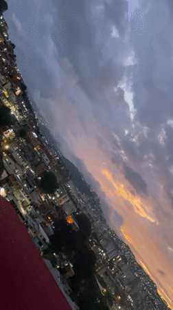 Dusk settles over Caracas hillsides amid dramatic cloudy skies