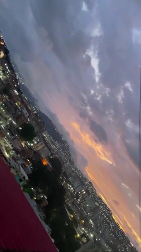 Dusk settles over Caracas hillsides amid dramatic cloudy skies