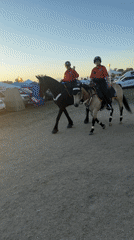 Mounted police patrol dusty Indio lot at sunset