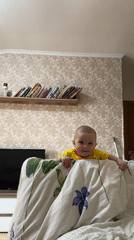 Cheerful baby captured smiling over furniture in Sochi
