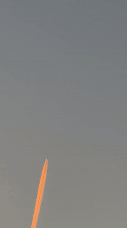 Orange contrail aircraft, crescent moon observed over Luxembourg morning