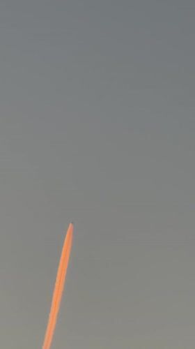 Orange contrail aircraft, crescent moon observed over Luxembourg morning