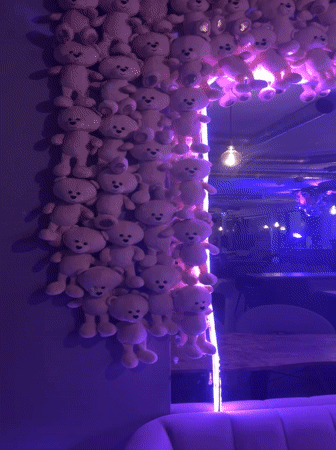 Neon-lit Tallinn space mixing teddy bears, mannequins, and Stormtroopers