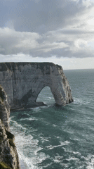 Woman poses at famous Étretat cliffs during evening photo session