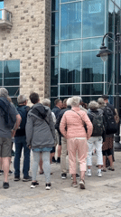 Twenty older adults gather on cobblestone plaza in Budva