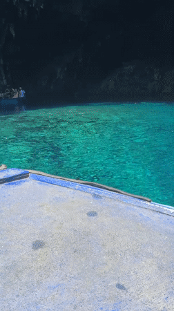 Boats exploring a turquoise sea cave near Sami, Greece
