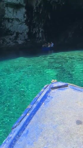 Boats exploring a turquoise sea cave near Sami, Greece