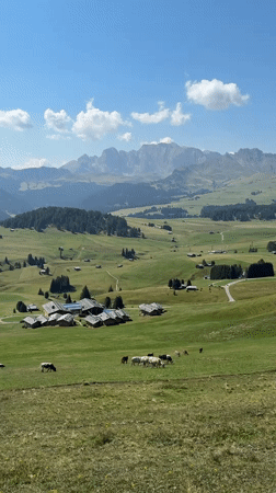 Summer morning at a Dolomites Alpine meadow and mountain huts