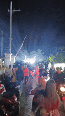 Nighttime street festival with DJ booth and glowing crowds in Pojok