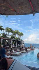 Poolside party with pizza and sushi, overlooking Thai islands.